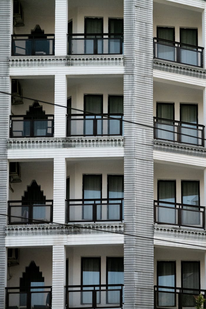 Detailed view of a modern multi-storey building facade with balconies and windows.